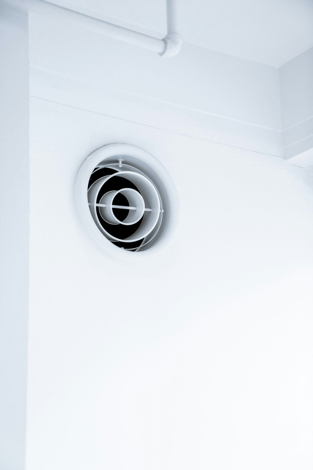 Bouche de ventilation ronde blanche sur un mur intérieur