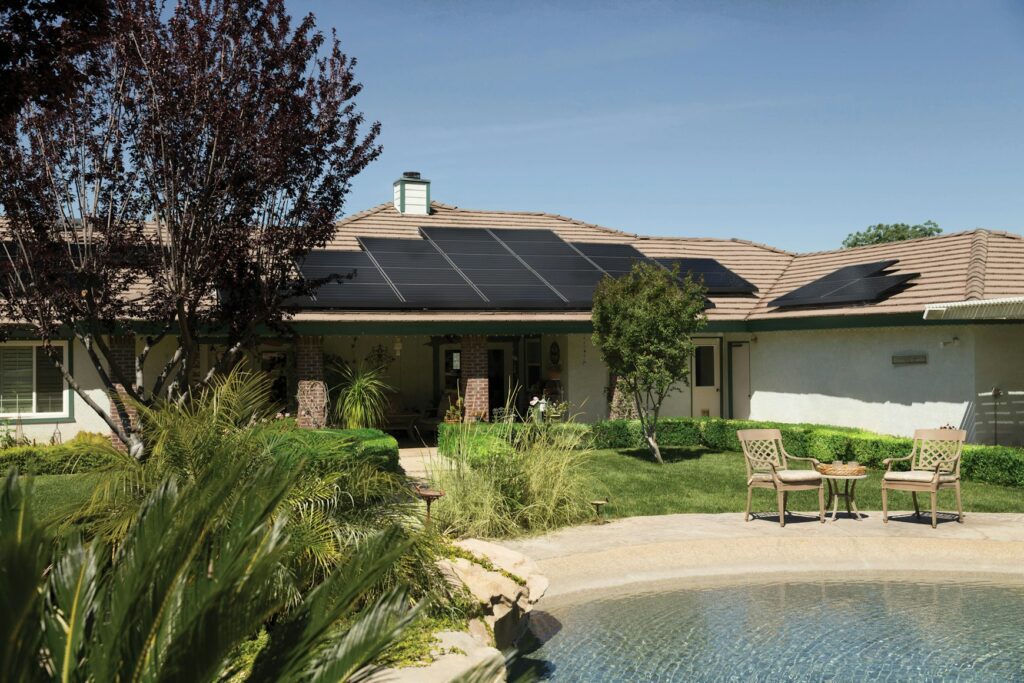 Panneaux solaires sur le toit d’une maison avec jardin et piscine